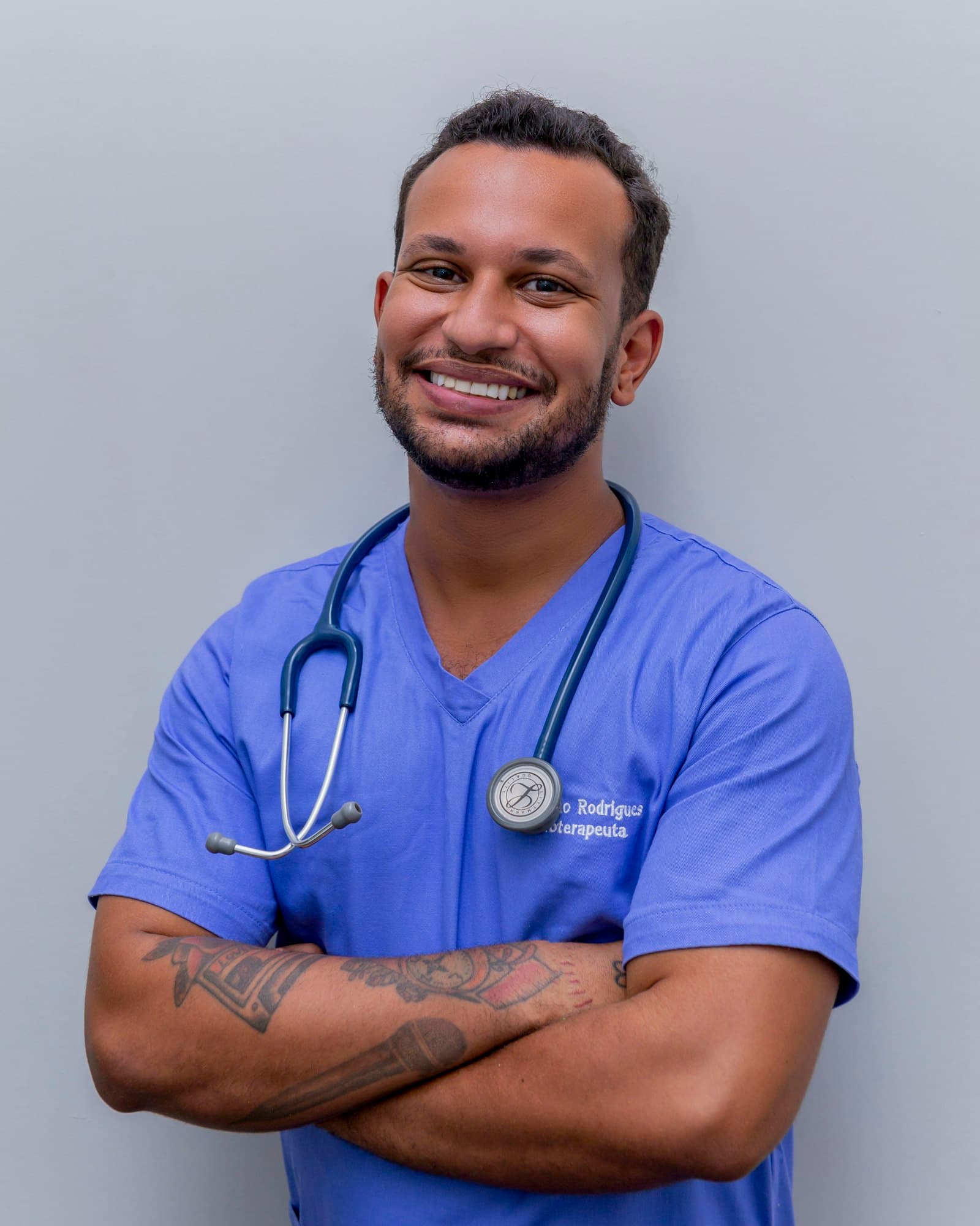 A smiling resident in scrubs with a stethoscope
